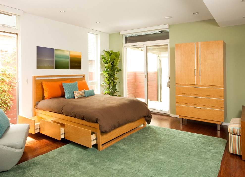 Photo of a contemporary bedroom in Los Angeles with green walls, medium hardwood floors and no fireplace.