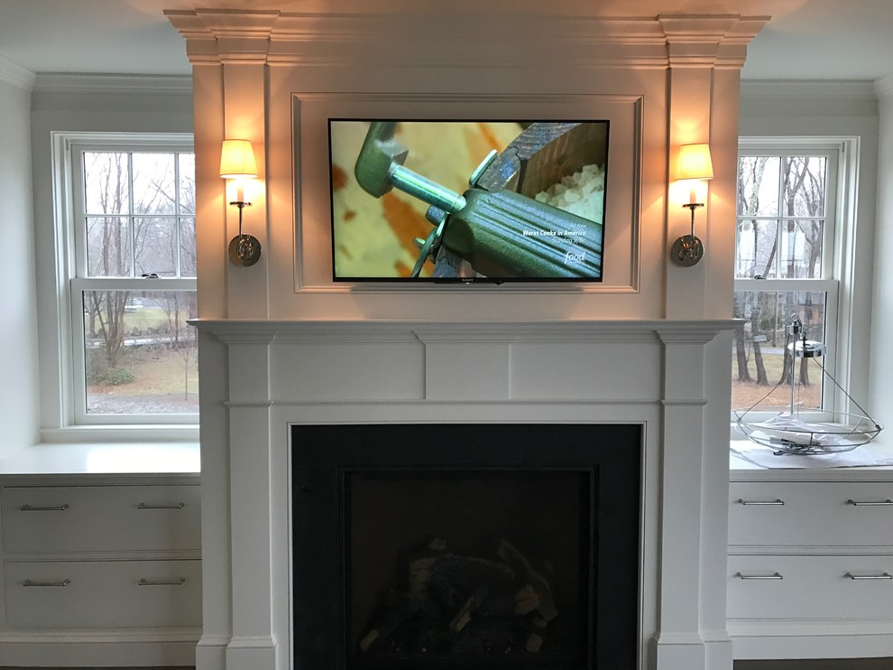 Photo of a small beach style master bedroom in Boston with blue walls, a standard fireplace and a wood fireplace surround.