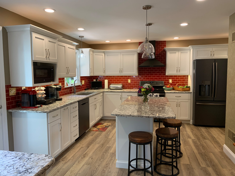 Transitional kitchen photo with red backsplash