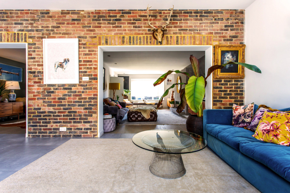 This is an example of a mid-sized contemporary open concept living room in Sussex with white walls, concrete floors, a wall-mounted tv, grey floor and brick walls.