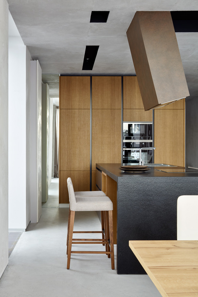Foto di una sala da pranzo aperta verso la cucina minimal di medie dimensioni con pareti grigie, pavimento in cemento e pavimento grigio