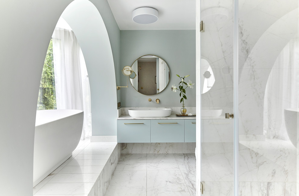 Design ideas for a mid-sized contemporary kids bathroom with flat-panel cabinets, turquoise cabinets, a freestanding tub, an open shower, a wall-mount toilet, white tile, marble, marble floors, a vessel sink, marble benchtops, white floor, a hinged shower door, white benchtops, a niche, a single vanity and a floating vanity.