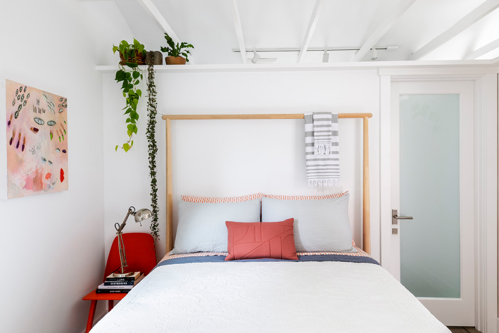 This is an example of a beach style guest bedroom in Portland with white walls, concrete floors and grey floor.