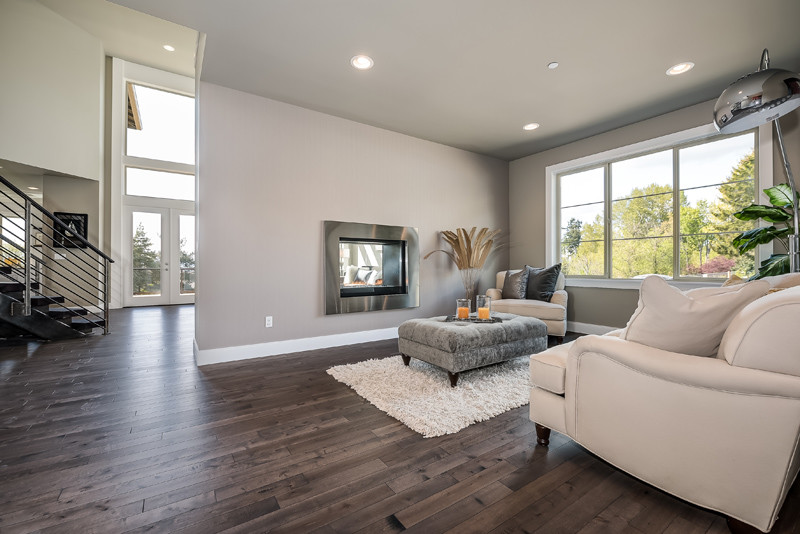 Inspiration for a large contemporary open concept living room in Seattle with grey walls, dark hardwood floors, a two-sided fireplace, a stone fireplace surround and a wall-mounted tv.