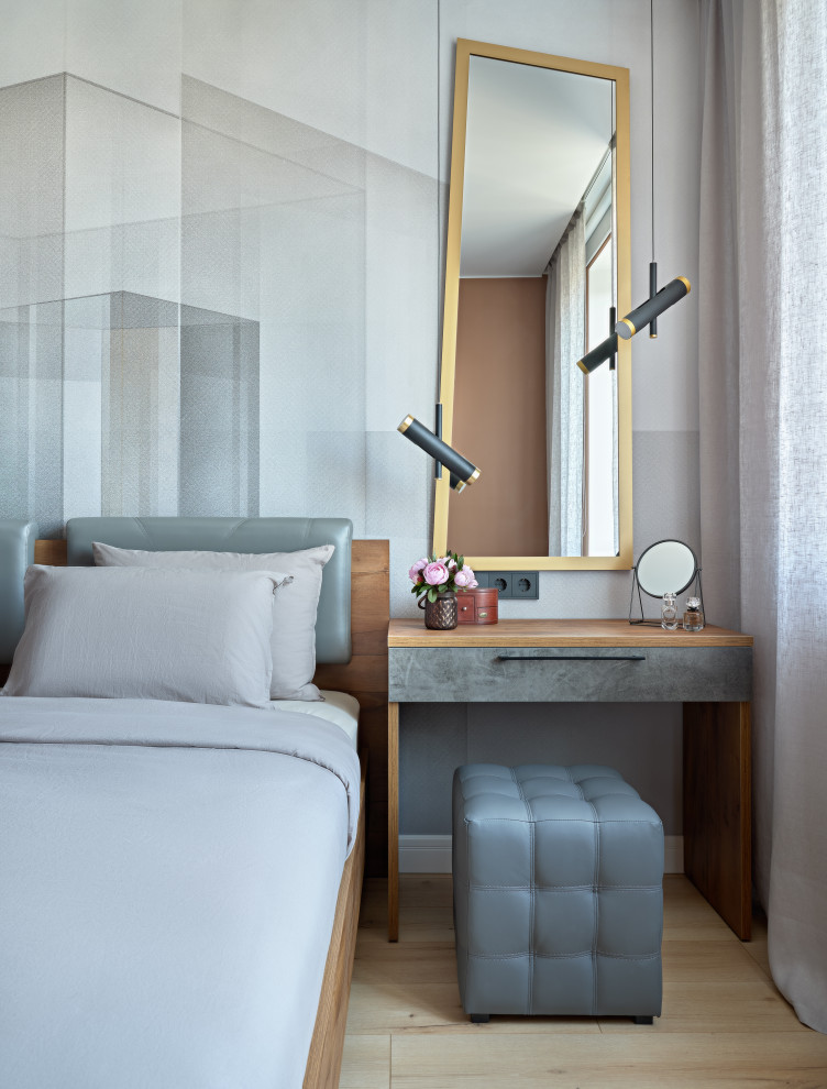 Стильный дизайн: хозяйская спальня среднего размера в стиле лофт с серыми стенами, полом из ламината, коричневым полом и акцентной стеной - последний тренд