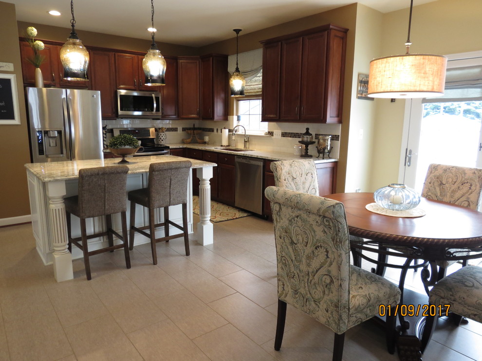 Eat-in kitchen - mid-sized transitional l-shaped ceramic tile eat-in kitchen idea with an undermount sink, raised-panel cabinets, distressed cabinets, granite countertops, white backsplash, porcelain backsplash, stainless steel appliances and an island