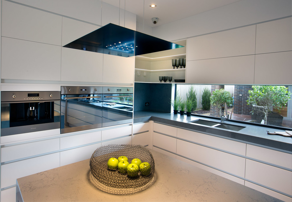 Design ideas for a contemporary kitchen in Melbourne with a double-bowl sink, flat-panel cabinets, white cabinets, stainless steel appliances and with island.
