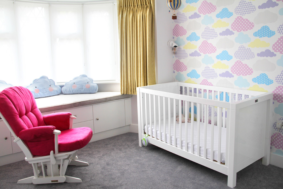 Design ideas for a mid-sized contemporary nursery for girls in London with pink walls, carpet and grey floor.