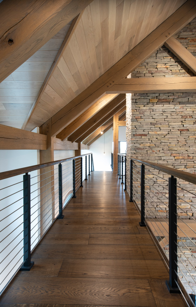 Hallway - rustic medium tone wood floor and exposed beam hallway idea