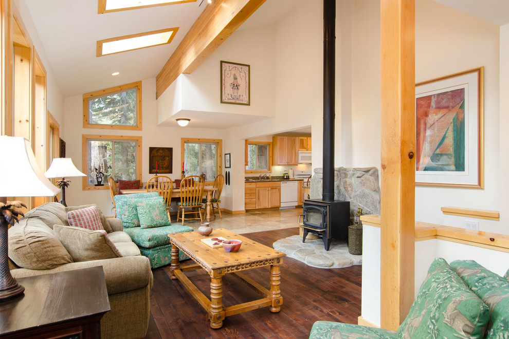 This is an example of a country open concept living room in Other with beige walls, dark hardwood floors, no tv and a wood stove.