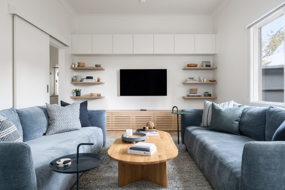 Inspiration for a contemporary living room in Melbourne with white walls, medium hardwood floors, a wall-mounted tv and brown floor.