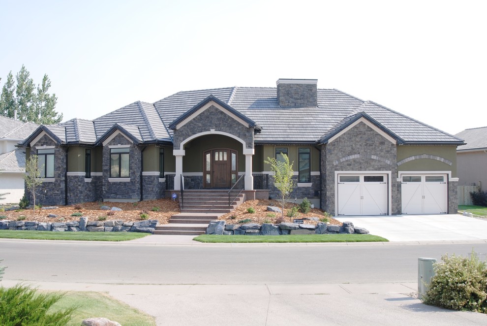Photo of a large traditional one-storey green exterior in Calgary with mixed siding.