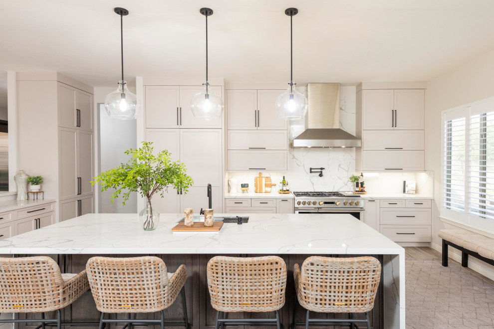 Transitional l-shaped gray floor kitchen photo in Phoenix with an undermount sink, shaker cabinets, beige cabinets, white backsplash, stone slab backsplash, stainless steel appliances, an island and white countertops