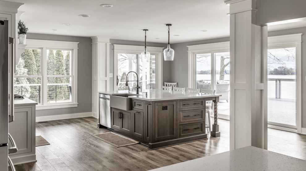 Inspiration for an expansive modern kitchen in Indianapolis with a farmhouse sink, flat-panel cabinets, dark wood cabinets, quartzite benchtops, grey splashback, ceramic splashback, stainless steel appliances, vinyl floors, with island, beige floor and white benchtop.