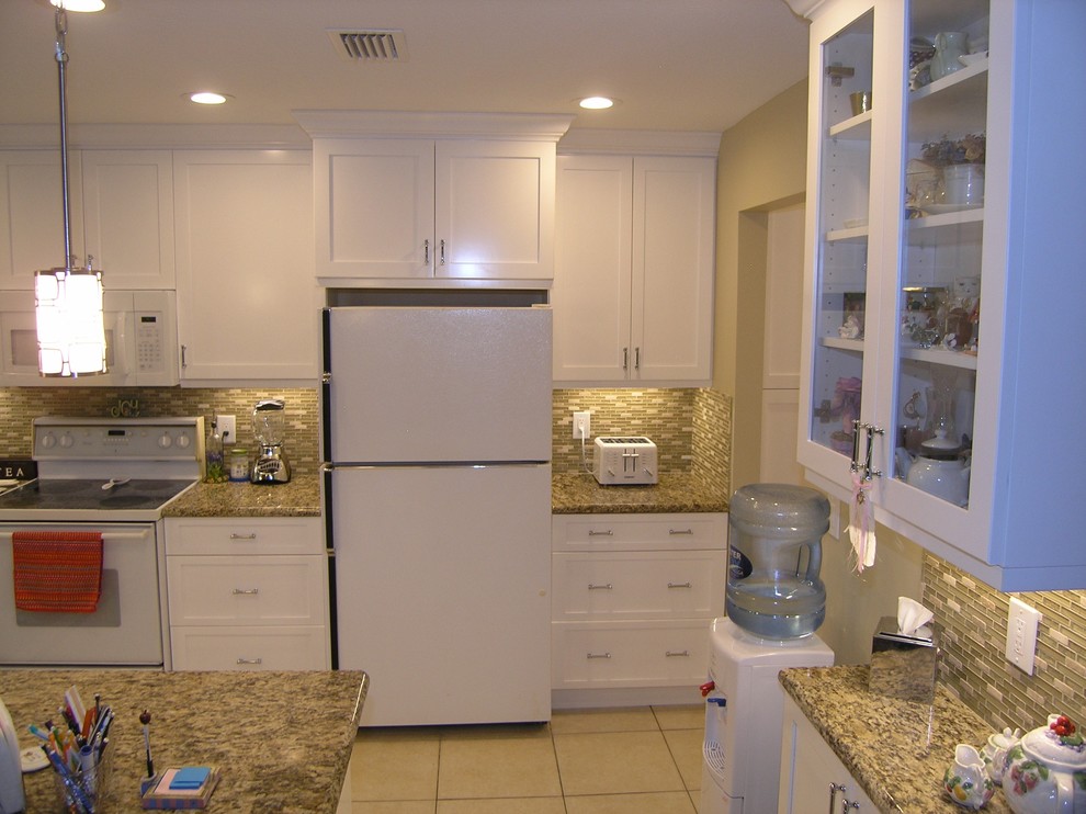This is an example of a mid-sized traditional u-shaped eat-in kitchen in Tampa with a double-bowl sink, shaker cabinets, white cabinets, granite benchtops, green splashback, matchstick tile splashback, stainless steel appliances, ceramic floors and with island.