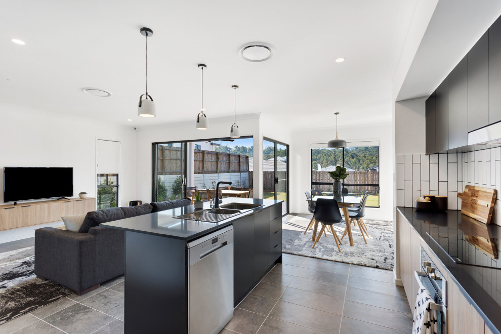 Mid-sized contemporary galley open plan kitchen in Brisbane with a double-bowl sink, black cabinets, quartz benchtops, white splashback, ceramic splashback, stainless steel appliances, ceramic floors, with island, grey floor and grey benchtop.