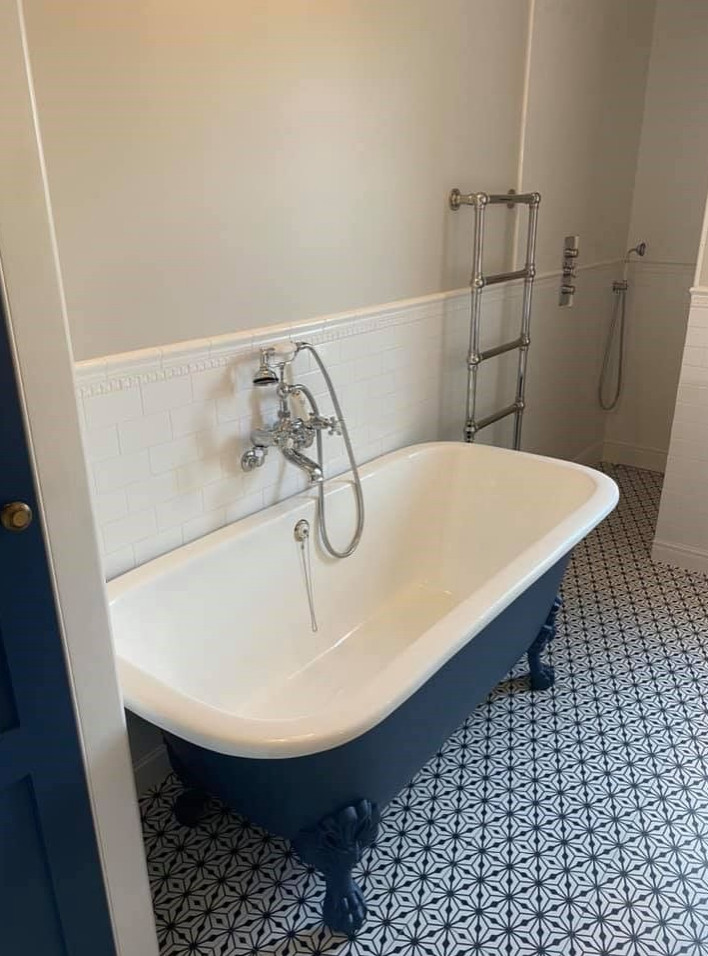 Klassisk inredning av ett mellanstort badrum för barn, med ett badkar med tassar, en dusch i en alkov, vit kakel, beige väggar, mosaikgolv, ett konsol handfat, flerfärgat golv och med dusch som är öppen