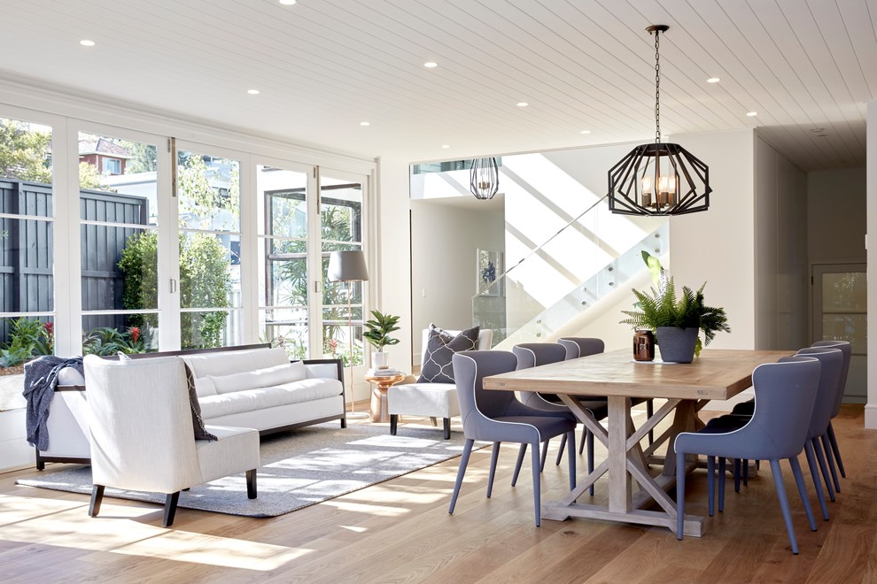 Design ideas for a transitional open plan dining in Sydney with white walls, light hardwood floors and beige floor.