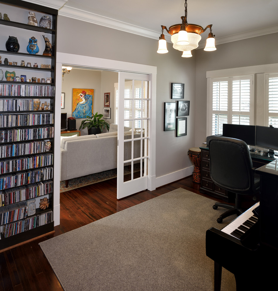 This is an example of a mid-sized arts and crafts home studio in Houston with grey walls, medium hardwood floors, no fireplace and a freestanding desk.