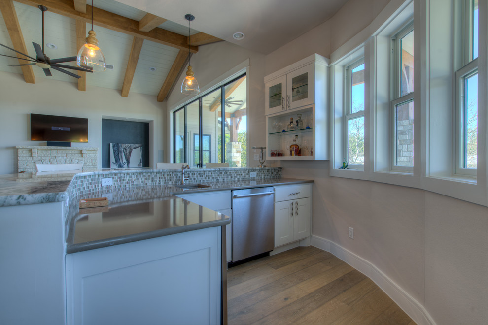 Example of a transitional eat-in kitchen design in Austin with stainless steel appliances and an island