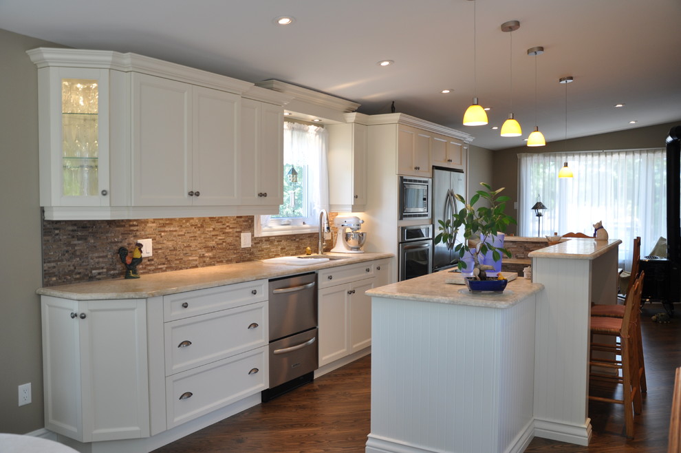 Inspiration for a large rustic single-wall dark wood floor eat-in kitchen remodel in Ottawa with an undermount sink, shaker cabinets, beige cabinets, granite countertops, brown backsplash, stone tile backsplash, stainless steel appliances and an island