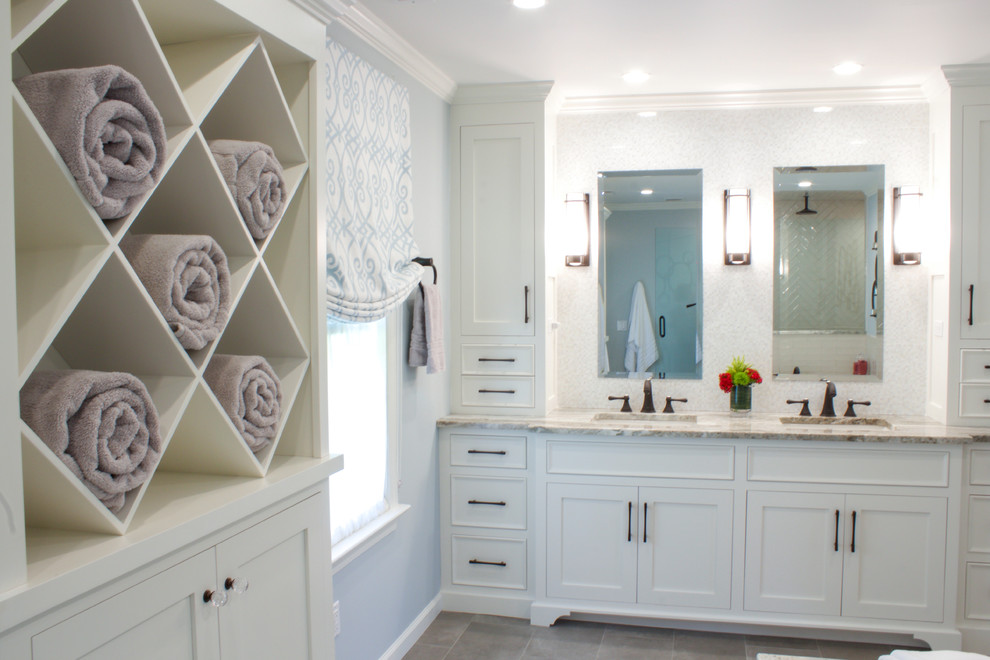 This is an example of a large traditional master bathroom in New York with flat-panel cabinets, white cabinets, a drop-in tub, a curbless shower, a one-piece toilet, beige tile, ceramic tile, grey walls, porcelain floors, an undermount sink, quartzite benchtops, grey floor, a hinged shower door and multi-coloured benchtops.