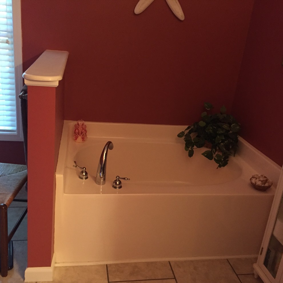 Example of a large transitional master gray tile and ceramic tile ceramic tile corner bathtub design with raised-panel cabinets, medium tone wood cabinets, a two-piece toilet, beige walls, an undermount sink and granite countertops