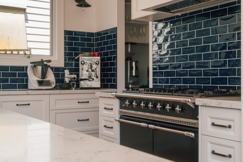 Inspiration for a mid-sized traditional kitchen in Melbourne with recessed-panel cabinets, white cabinets, quartz benchtops, blue splashback and ceramic splashback.