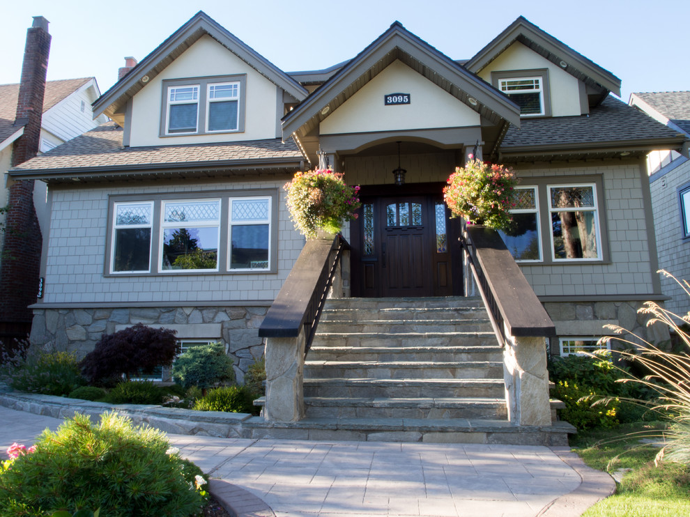 Photo of a large transitional two-storey beige exterior in Vancouver with mixed siding and a gable roof.