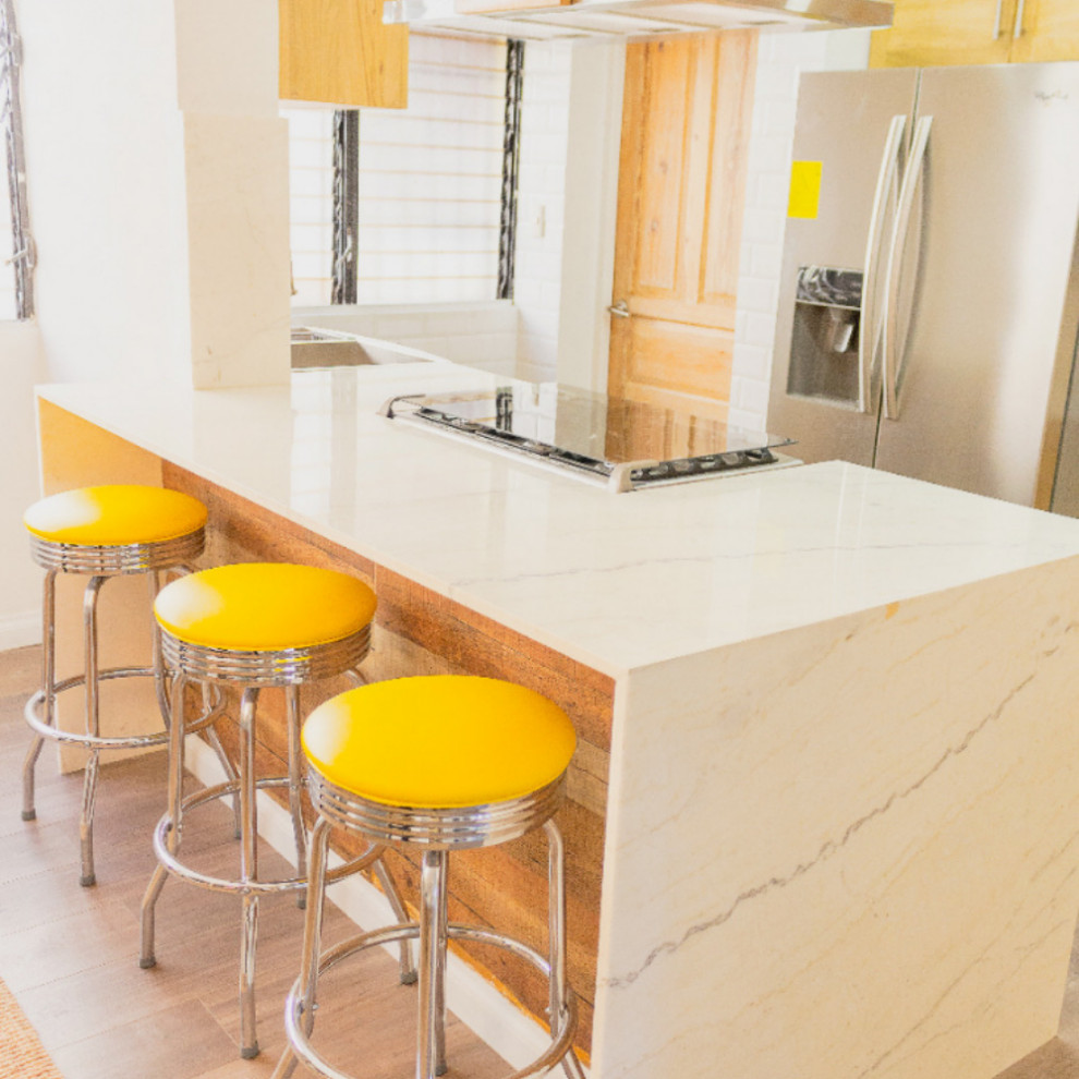 Example of a mountain style brown floor eat-in kitchen design with brown cabinets, quartzite countertops, white backsplash, subway tile backsplash, stainless steel appliances and white countertops