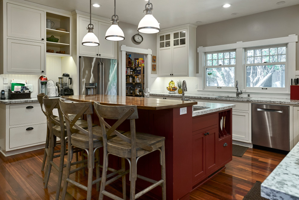 Kitchen - mid-sized craftsman l-shaped medium tone wood floor and red floor kitchen idea in San Francisco with an undermount sink, shaker cabinets, white cabinets, granite countertops, white backsplash, wood backsplash, white appliances, an island and gray countertops