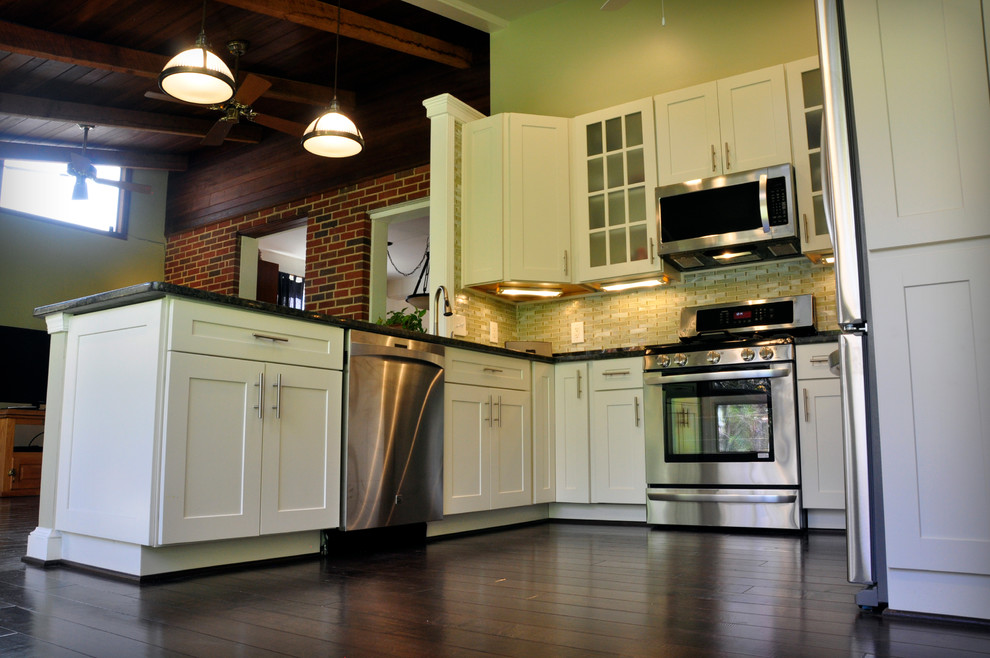 Eat-in kitchen - mid-sized transitional u-shaped dark wood floor eat-in kitchen idea in DC Metro with an undermount sink, shaker cabinets, white cabinets, granite countertops, yellow backsplash, glass tile backsplash, stainless steel appliances and a peninsula
