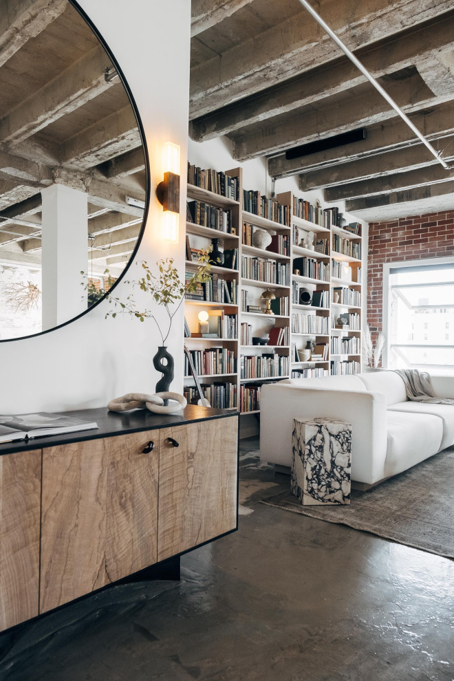 Mid-sized industrial loft-style living room in Other with white walls, concrete floors, no fireplace, a concealed tv, grey floor, exposed beam and brick walls.