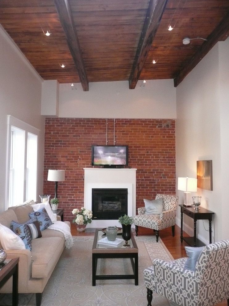 This is an example of a mid-sized contemporary open concept family room in Boston with white walls, medium hardwood floors, a standard fireplace, a plaster fireplace surround, a freestanding tv and brown floor.