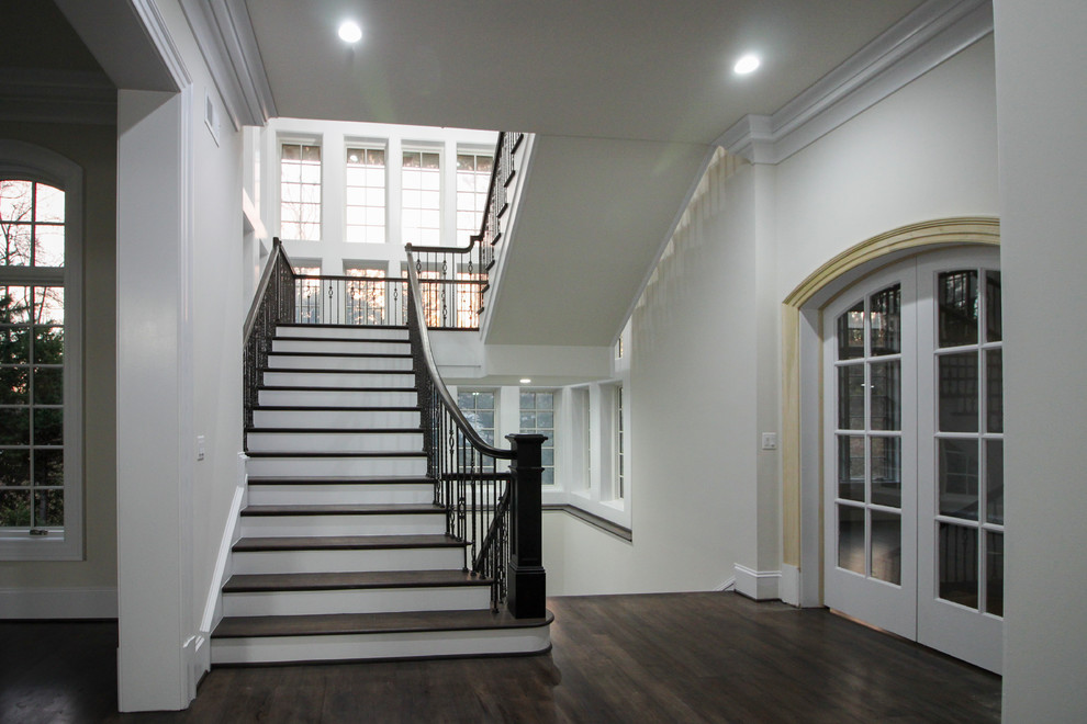 This is an example of a large transitional wood floating staircase in DC Metro with wood risers and glass railing.