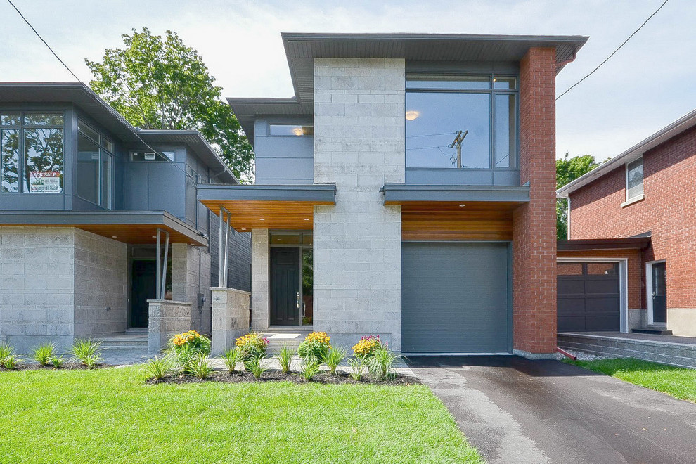 Large contemporary two-storey grey house exterior in Ottawa with mixed siding, a flat roof and a shingle roof.