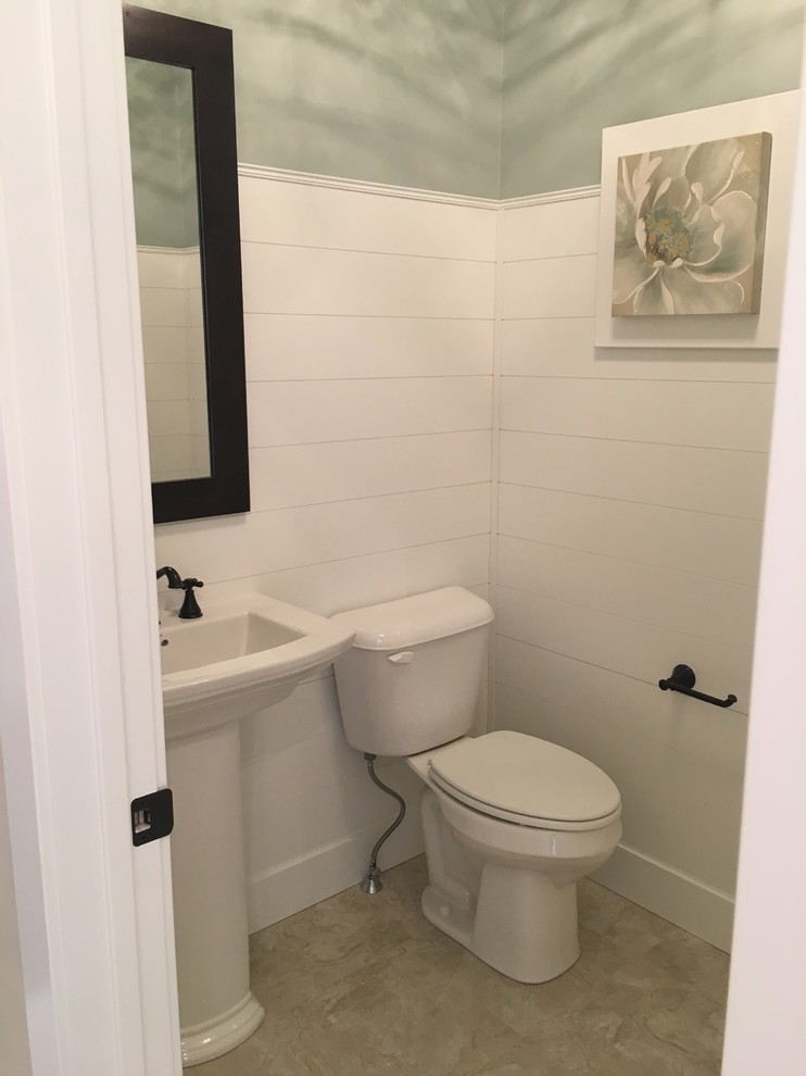 This is an example of a mid-sized arts and crafts powder room in Other with a two-piece toilet, gray tile, porcelain tile, grey walls, porcelain floors, a pedestal sink and solid surface benchtops.