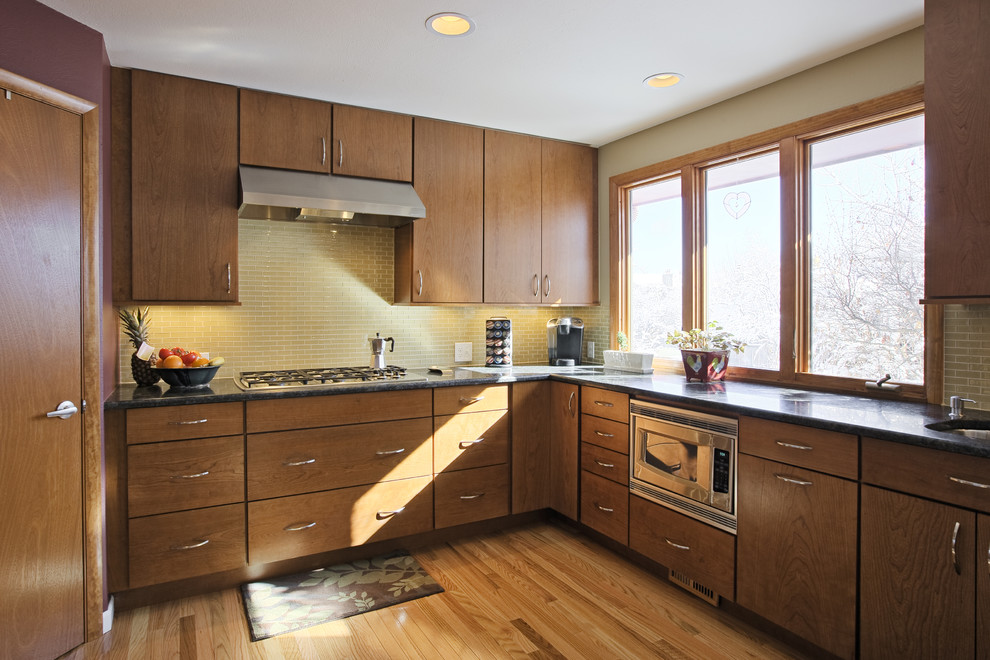 Example of a large light wood floor eat-in kitchen design in Minneapolis with an undermount sink, medium tone wood cabinets, beige backsplash and stainless steel appliances