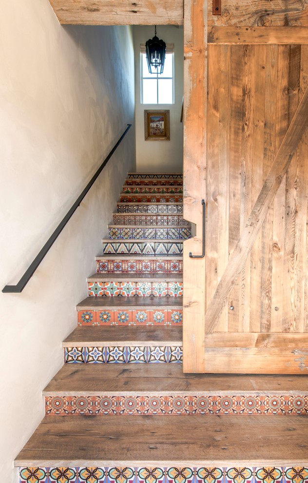 Inspiration for a large country wood l-shaped staircase in Austin with tile risers and metal railing.