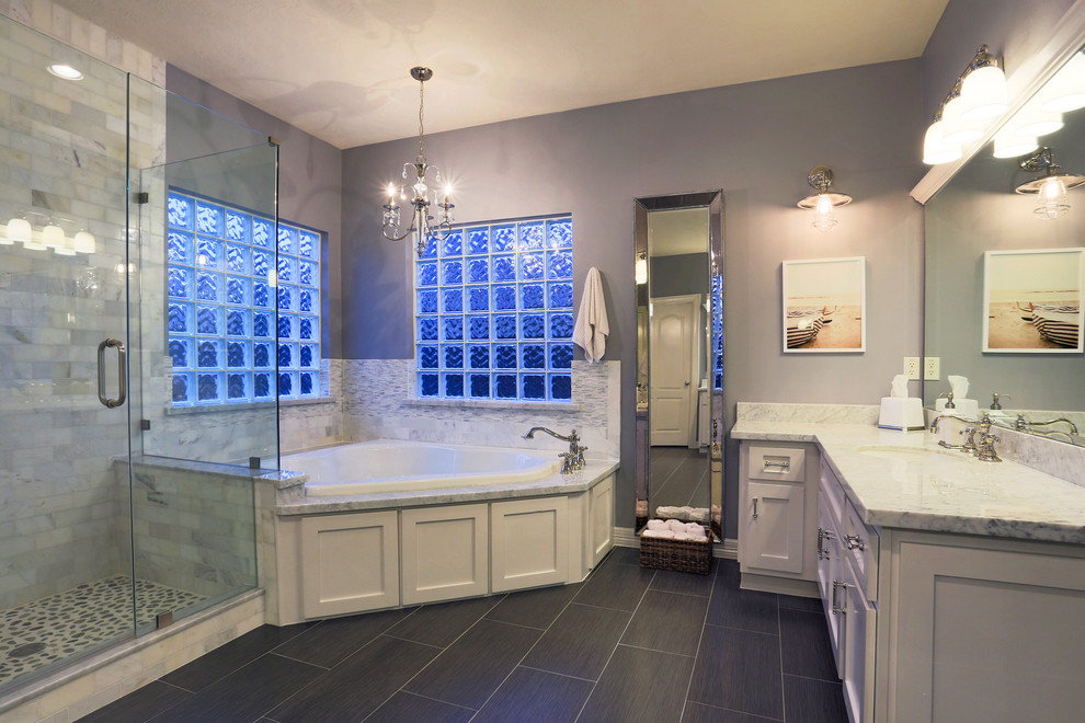 Example of a mid-sized transitional master gray tile and ceramic tile ceramic tile corner bathtub design in Houston with white cabinets, gray walls, an undermount sink, shaker cabinets and marble countertops