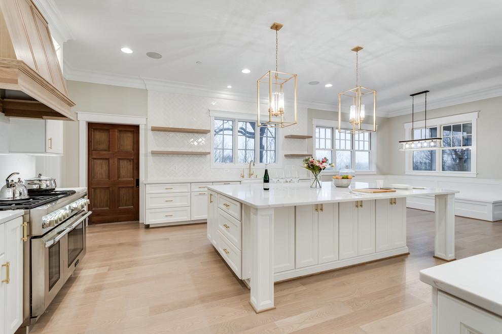 Example of a huge transitional kitchen design in Baltimore with flat-panel cabinets, white cabinets, marble countertops, white backsplash, subway tile backsplash, stainless steel appliances and an island