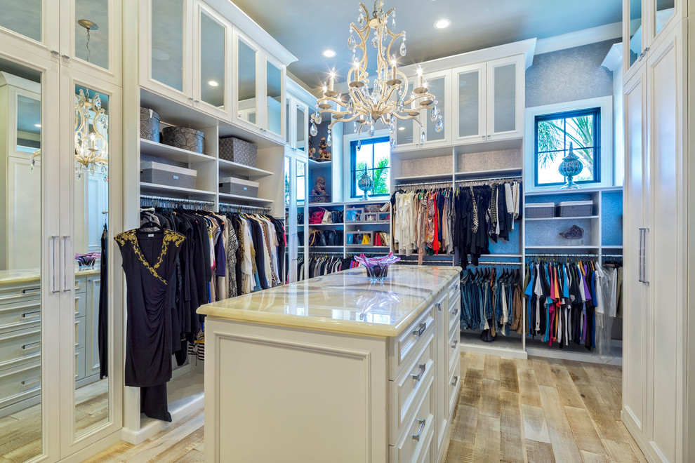 Design ideas for a large transitional women's walk-in wardrobe in Other with recessed-panel cabinets, white cabinets and light hardwood floors.