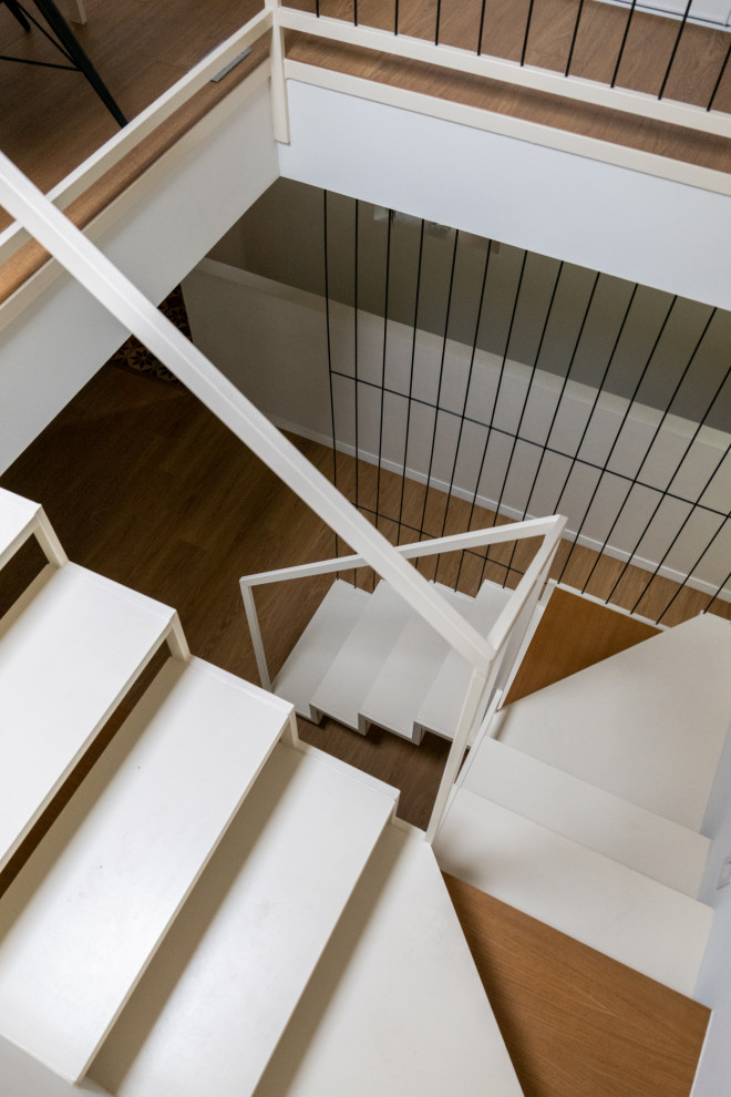 Große Mediterrane Treppe in U-Form mit gebeizten Holz-Treppenstufen und Stahlgeländer in Paris