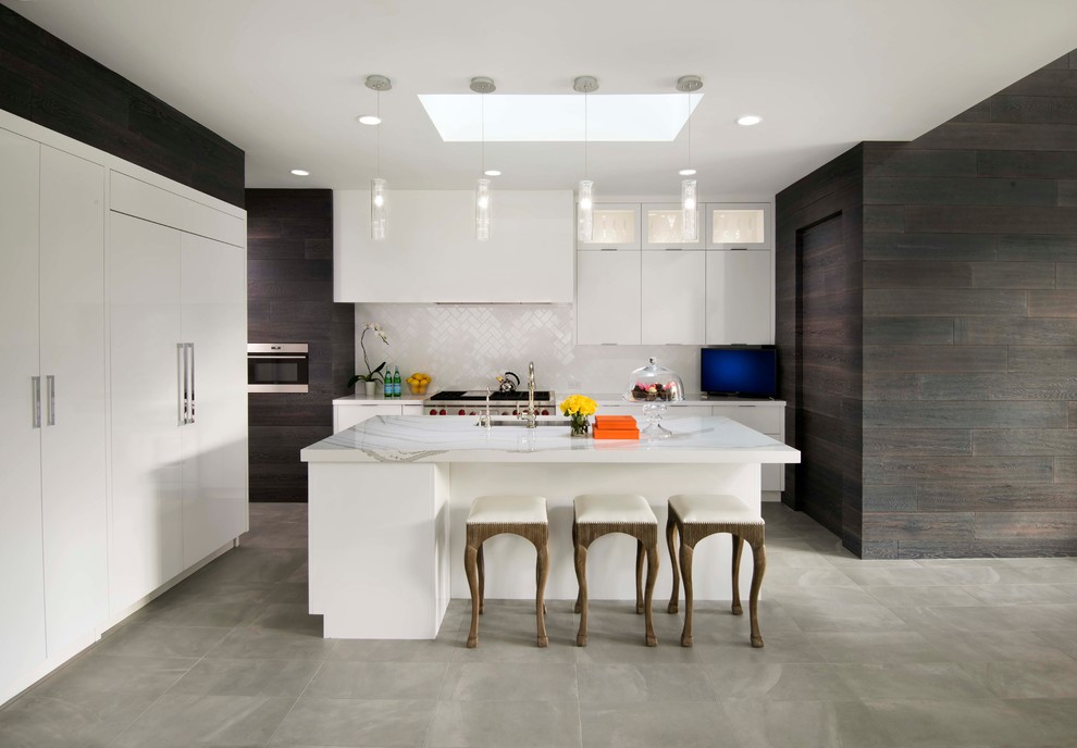 Large contemporary l-shaped open plan kitchen in Phoenix with an undermount sink, flat-panel cabinets, white cabinets, white splashback, panelled appliances, with island, grey floor, white benchtop, marble benchtops and subway tile splashback.