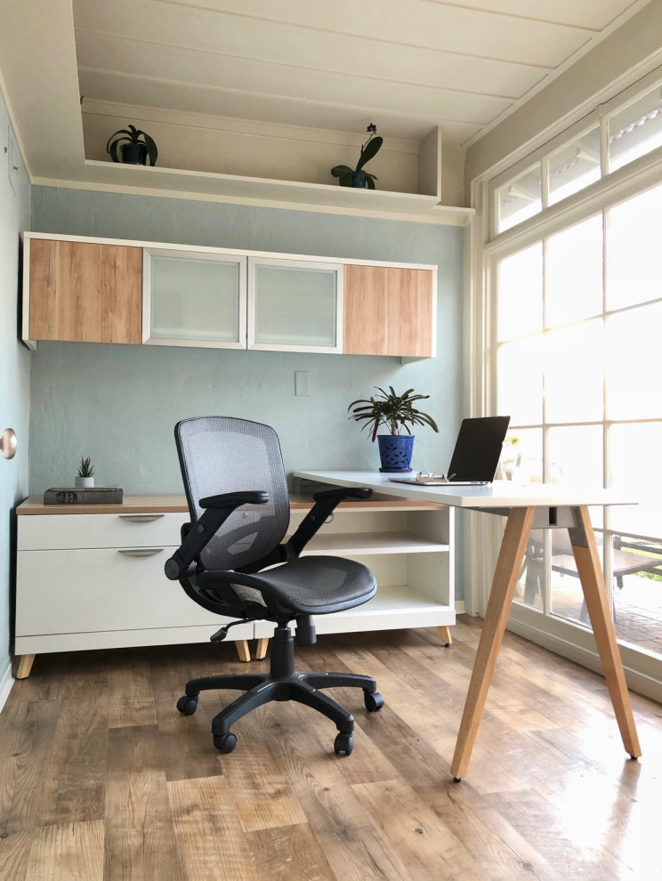 Inredning av ett modernt litet arbetsrum, med blå väggar, vinylgolv och ett fristående skrivbord