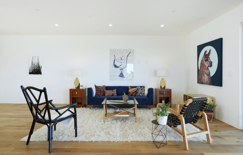 Photo of an eclectic living room in Los Angeles with white walls and medium hardwood floors.