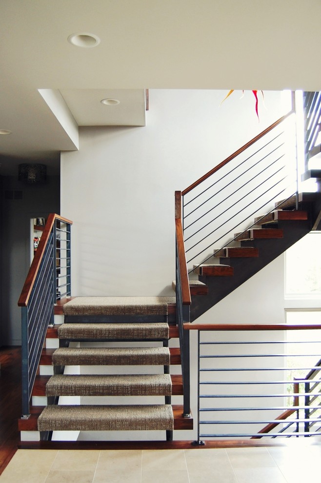 Photo of a large contemporary carpeted u-shaped staircase in Kansas City with open risers.