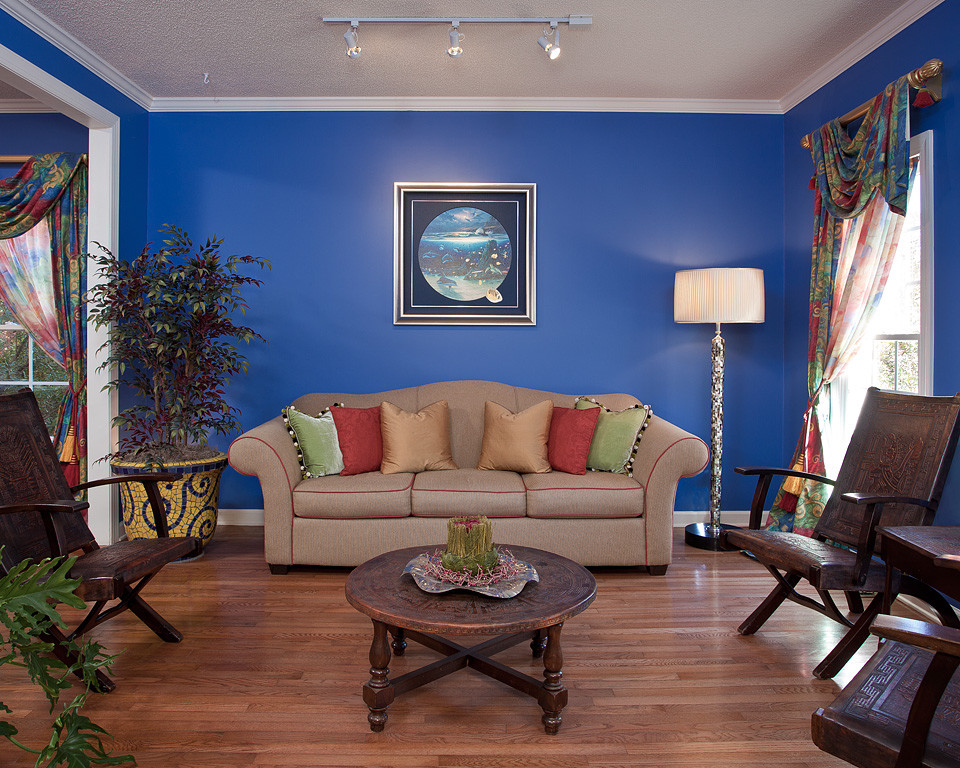 Example of a mid-sized eclectic open concept medium tone wood floor living room design in Raleigh with blue walls, no fireplace and no tv