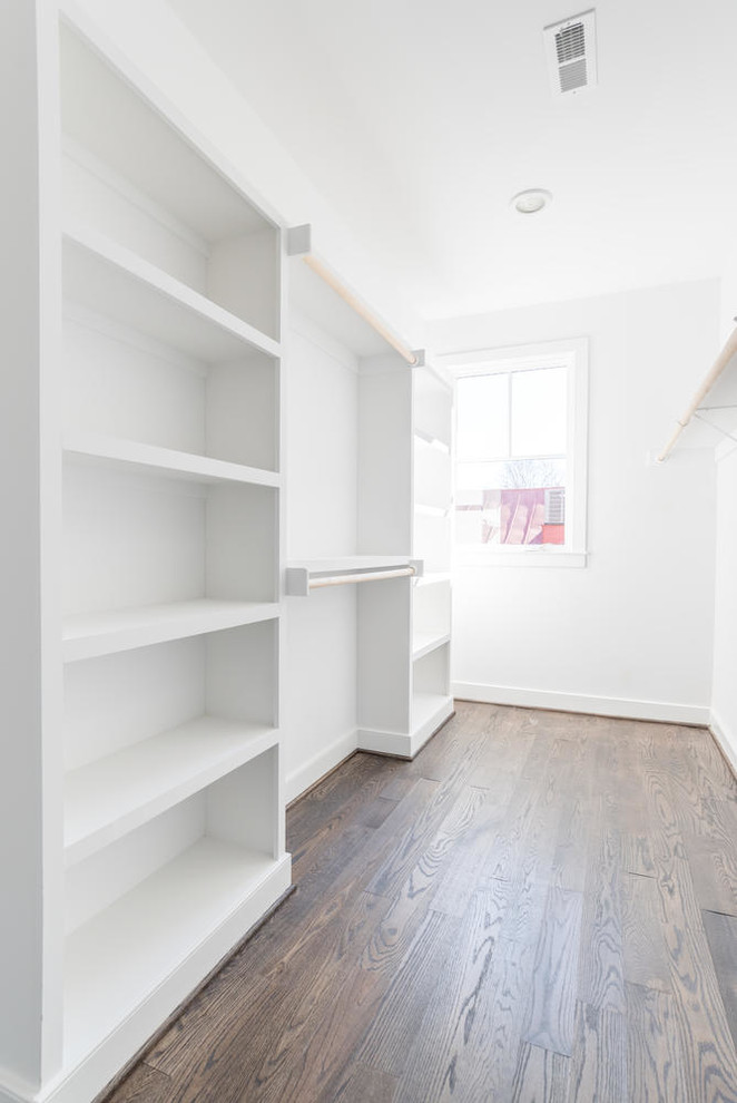 This is an example of a contemporary walk-in wardrobe in DC Metro with open cabinets, white cabinets and dark hardwood floors.