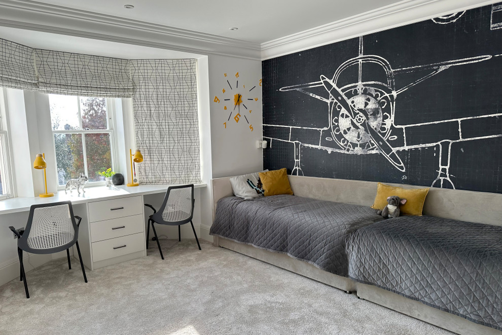Photo of a mid-sized contemporary kids' room for boys in London with white walls, carpet, beige floor and wallpaper.